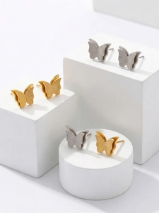 Macro shot of gold and silver butterfly studs with dual-layer matte and polished textures