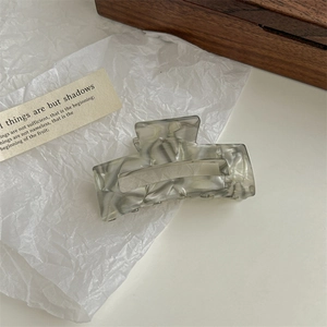 Detail of grey marble textured square hair claw clip on aesthetic white background