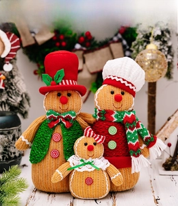 Close-up of three knitted gingerbread man figures with festive scarves and buttons