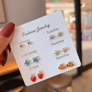 Detailed set of 6 pairs of gold-plated alloy stud earrings on a weekly fashion display card