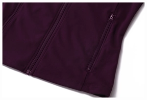 Detail of a dark purple sports jacket featuring a secure side zipper pocket and smooth fabric