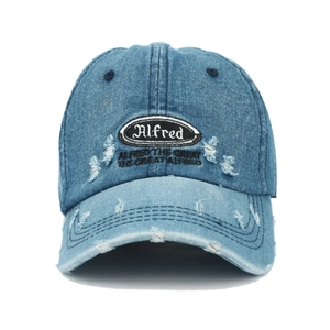 Detailaufnahme der hellblauen Denim-Baseballkappe mit Alfred-Stickerei und Rissverzierung