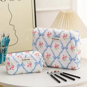 Detailed macro view of quilted floral cosmetic bags set with blue bows and pink roses
