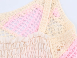 Detail of pink crochet knit bodice with beige smocked fabric texture on a summer top