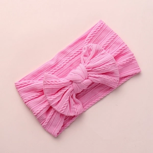 Detail of hot pink cable knit baby headband showing texture and large bow accessory