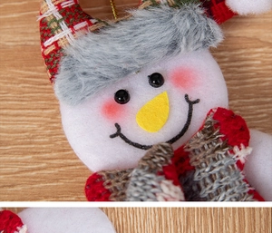 Detailed close-up of a plush snowman ornament featuring a red plaid hat and knit scarf