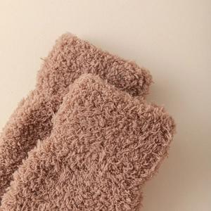 Close-up of soft coral fleece material on pink five-finger winter socks for warmth