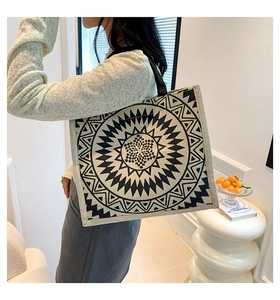 Detailed close-up of large linen tote bag featuring black geometric ethnic patterns