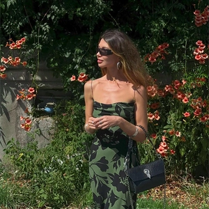 Detail shot of a slim strap floral maxi dress featuring a low back and abstract print