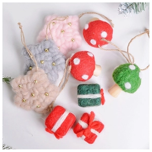 Close-up of handmade wool felt Christmas ornaments with star, mushroom, and gift shapes