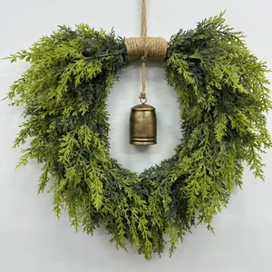 Close-up of artificial cedar Christmas wreath with a rustic bronze metal bell center