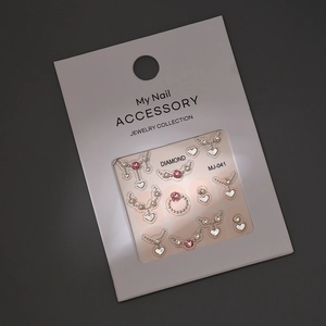 Detail view of heart-shaped nail art stickers with pink crystals and silver frames