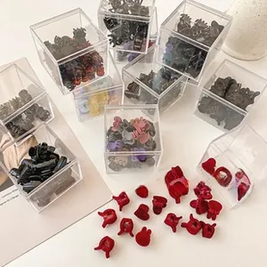 Close-up of mini matte hair clips in colorful candy tones and acrylic storage boxes