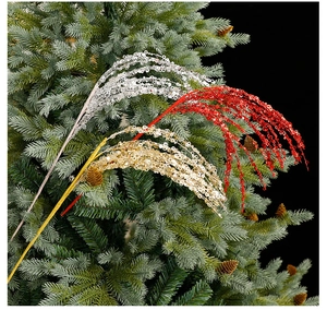 Close-up of sparkling red and gold sequin fireworks picks on a lush Christmas tree branch