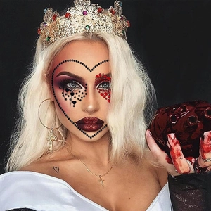 Close-up of Halloween crystal face gems with gold crown and cross jewelry accessories