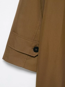 Detailed macro view of the sleeve cuff with a black button and fine twill cotton fabric texture