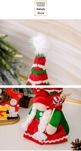 Detail of Christmas gnome plush doll with red green knit hat and white braids decor
