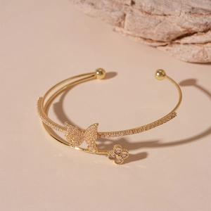 Close-up of double-layer gold bangle with zircon butterfly and flower charms
