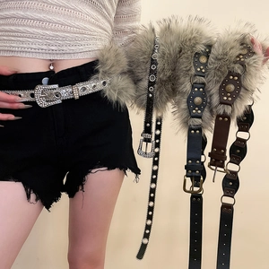 Détail d'une ceinture punk Y2K avec bordure en fausse fourrure et rivets argentés