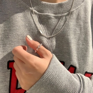 Detailed close-up of 925 sterling silver chain ring and minimalist necklace on a model