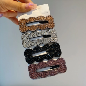 Set of four glittering wavy rhinestone hair clips in champagne, silver, black and purple