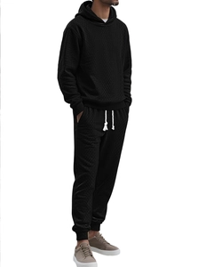 Detail showing the geometric knit texture and fabric of the black men's tracksuit set