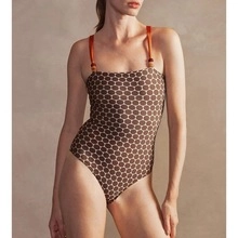 Detail of pearl beads on orange shoulder straps with brown geometric dot swimsuit print