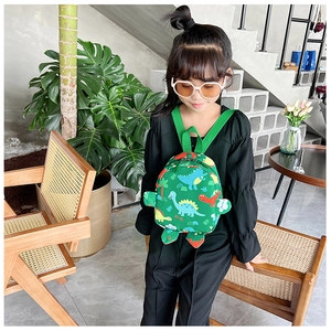 Detail of cute green dinosaur backpack with cartoon patterns and 3D shell side feature