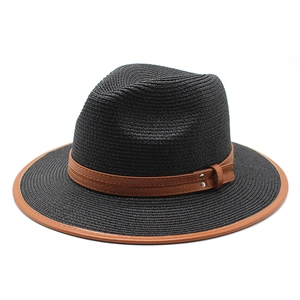 Détail du chapeau de paille noir avec bordure en cuir marron et rivets métalliques