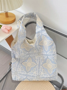Light blue floral butterfly embroidery tote bag with chic pleated straps in home setting