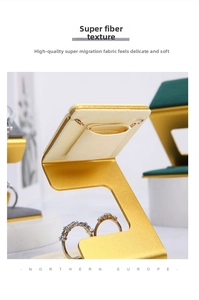 Detailed view of luxury C-shaped jewelry stand with gold metal frame and cream microfiber