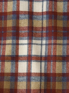 Detailed macro view of the classic tartan plaid fabric with red, blue and beige woven lines