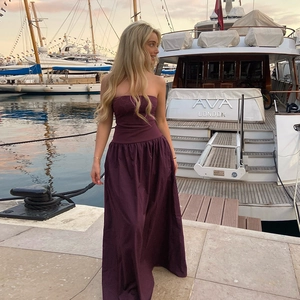 Deep purple tube maxi dress with a fitted waist and flared hem at the marina
