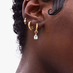 Detailed view of S925 sterling silver opal earrings with gold plating on model ear