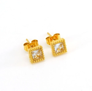 Macro detail of gold-plated square zircon earrings with a clear cubic zirconia inlay