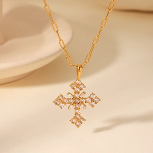 Vue macro d'un collier pendentif croix doré orné de zircons cubiques transparents