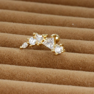 Détail macro du piercing d'oreille doré avec zircons et fermoir à boule vissée