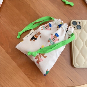 Detail of drawstring cotton pouch featuring cute bear print and vibrant green cords