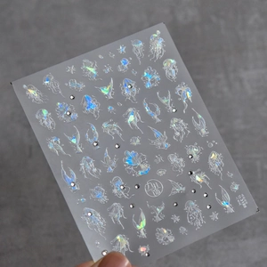 Macro shot of seashell mermaid nail stickers with holographic laser and 3D gems