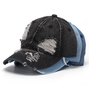 Gros plan de casquettes de baseball en jean vieilli avec trous effilochés en noir et bleu