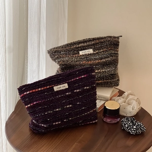 Detail of wool tweed cosmetic bags with textured knit fabric and simple wish labels