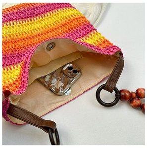 Top view of rainbow straw bag showing beige lining interior and brown leather strap