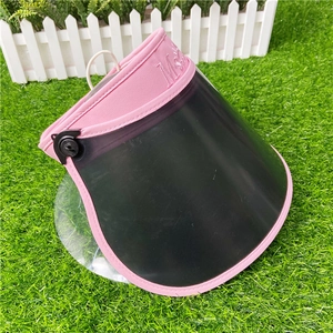 Close-up detail of a pink sun visor hat with a transparent black shield and embossed logo