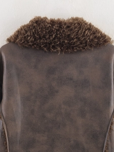Detailed close-up of thick faux fur collar and textured dark brown leather jacket