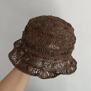 Detail of hand-woven hollow crochet straw bucket hat with breathable wave-edge design