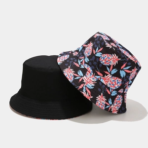 Double-sided reversible bucket hat featuring black fabric and vibrant pineapple print patterns
