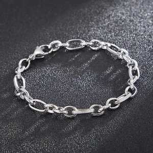 Detail view of a stainless steel hip hop bracelet with engraved oval chain links.