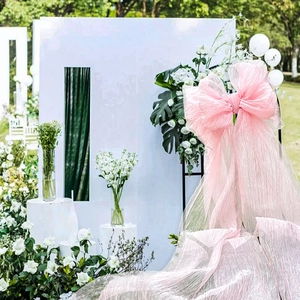 Large pink organza bow decoration for outdoor wedding events and celebration backdrops