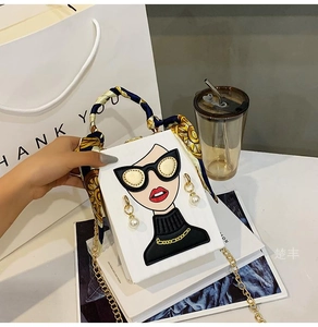 Detail of white graffiti bag with cartoon print, pearl decor and silk scarf handle