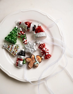 Christmas glass ornament set with Santa and snowman shapes on a white ceramic plate